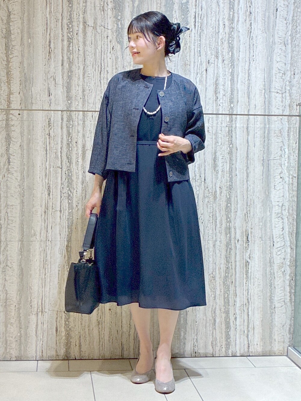 ブルー系のノーカラージャケット、ブルー系のワンピース、ブラック系のトートバッグを着用したレディースの夏コーディネートの5枚目の写真