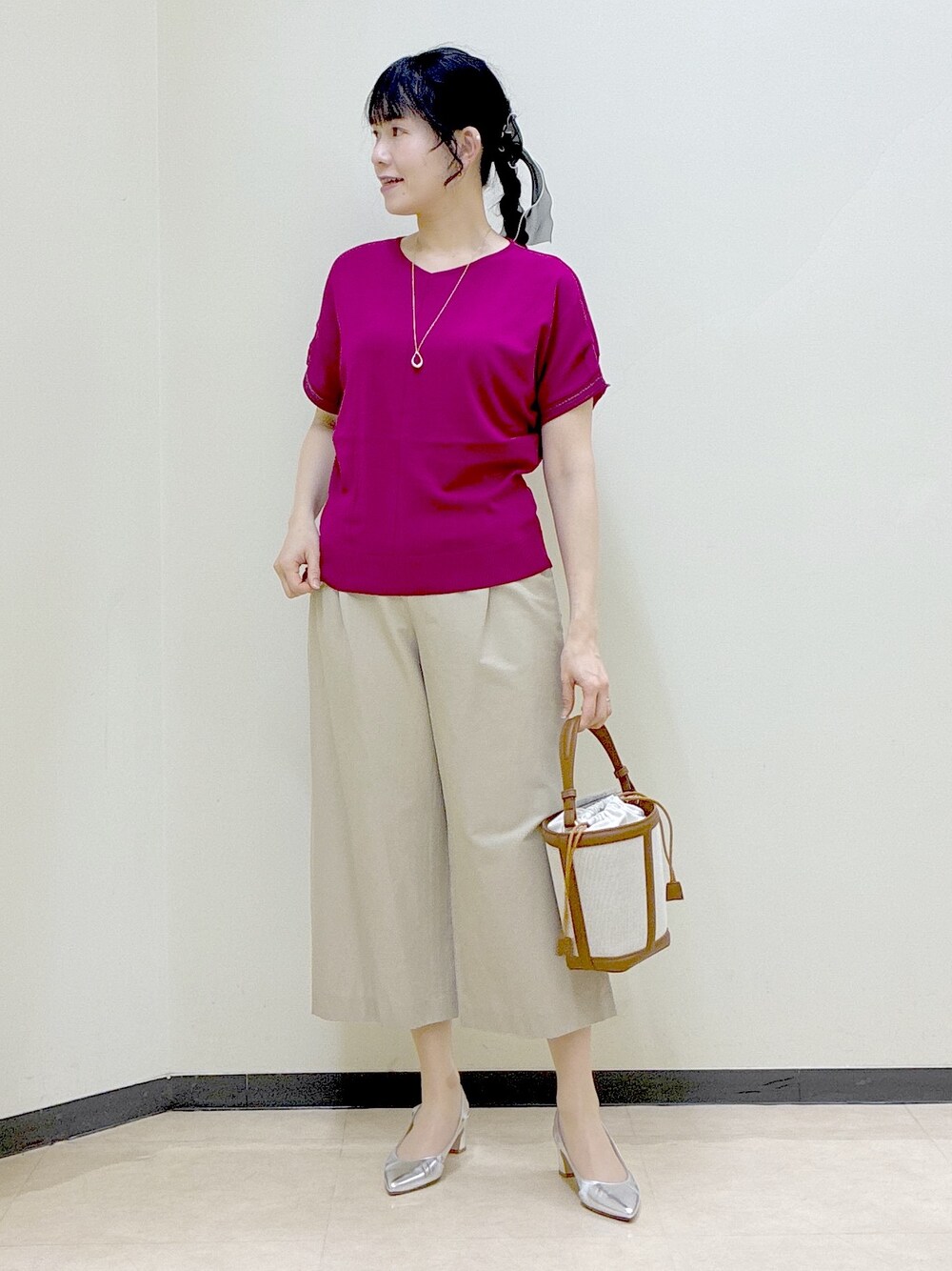ピンク系のニット/セーター、ベージュ系のその他パンツ、イエロー系のショルダーバッグを着用したレディースの春コーディネートの10枚目の写真