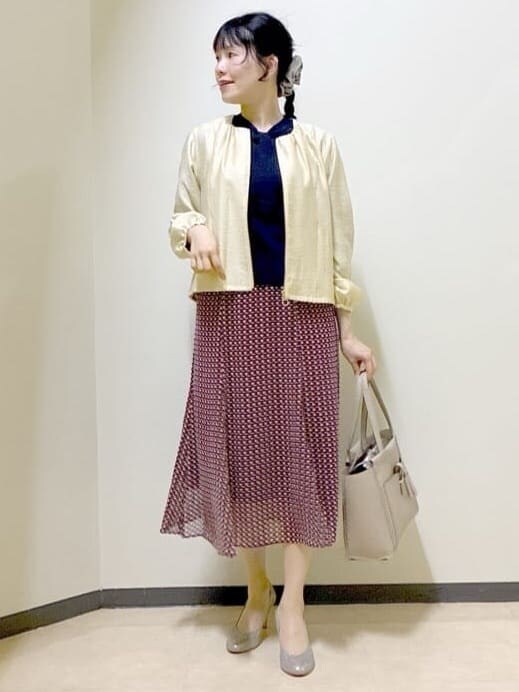ベージュ系のブルゾン、ブルー系のニット/セーター、レッド系のスカートを着用したレディースの春コーディネートの6枚目の写真
