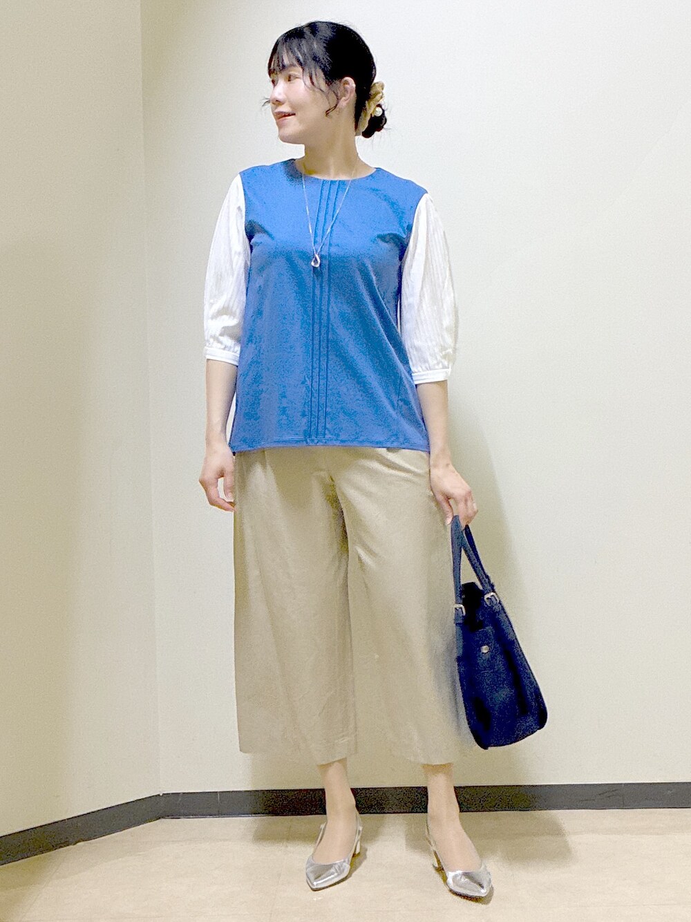 ブルー系のTシャツ/カットソー、ベージュ系のその他パンツ、ブルー系のショルダーバッグを着用したレディースの春コーディネートの5枚目の写真