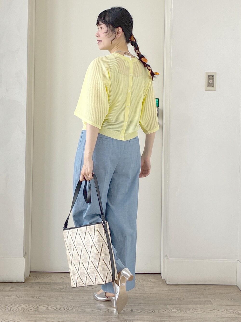 ブルー系のその他パンツ、ベージュ系のショルダーバッグ、イエロー系のニット/セーターを着用したレディースの春コーディネートの4枚目の写真