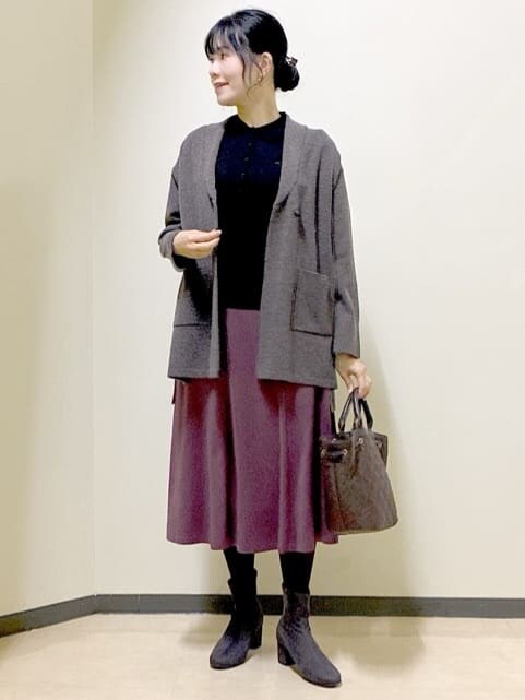 ブラウン系のカーディガン/ボレロ、ブラック系のニット/セーター、レッド系のスカートを着用したレディースの冬コーディネートの6枚目の写真