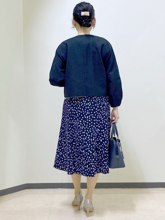 ブルー系のノーカラージャケット、グレー系のニット/セーター、ブルー系のスカートを着用したレディースの冬コーディネートの3枚目の写真