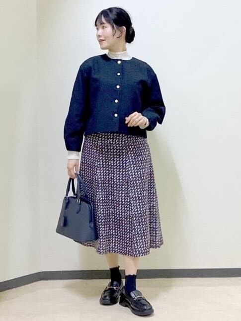 ブルー系のノーカラージャケット、ベージュ系のニット/セーター、ブルー系のスカートを着用したレディースの冬コーディネートの7枚目の写真