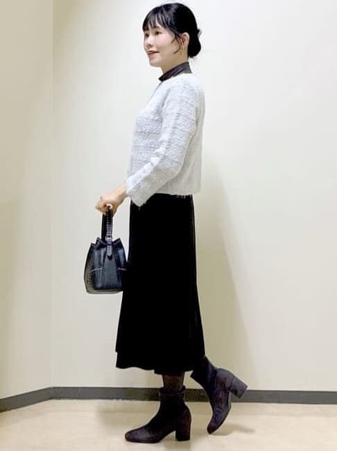グレー系のカーディガン/ボレロ、グレー系のニット/セーター、ブラック系のスカートを着用したレディースの冬コーディネートの2枚目の写真