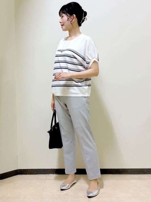 ホワイト系のニット/セーター、グレー系のその他パンツ、ブラウン系のスカートを着用したレディースの夏コーディネートの6枚目の写真