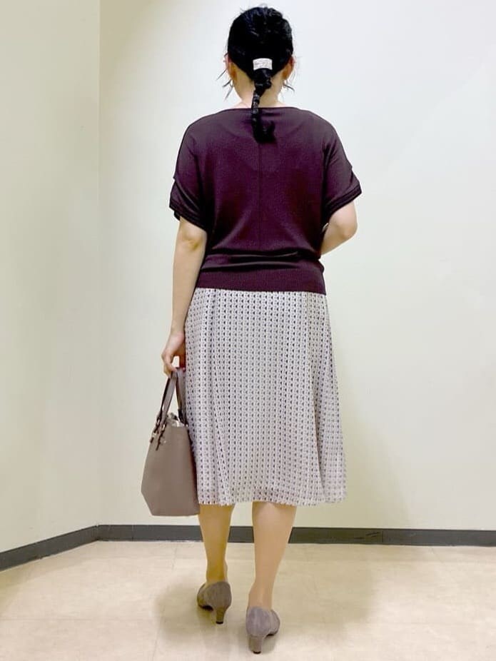 ブラウン系のニット/セーター、ベージュ系のスカート、レッド系のTシャツ/カットソーを着用したレディースの夏コーディネートの3枚目の写真