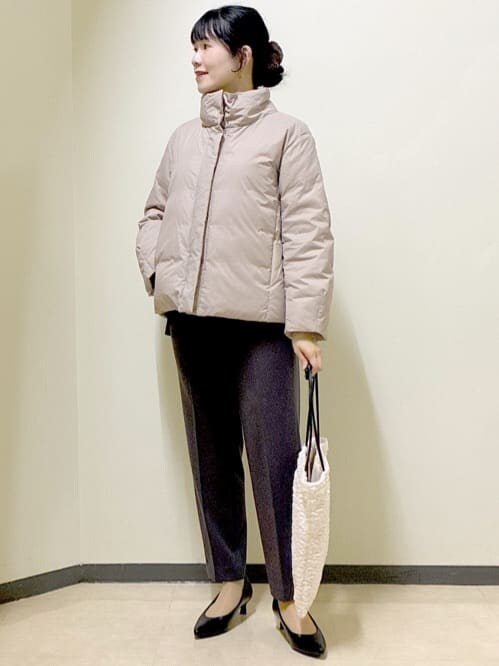 ブラック系のニット/セーター、ブラウン系のその他パンツ、ベージュ系のダウンジャケット/コートを着用したレディースの秋コーディネートの10枚目の写真