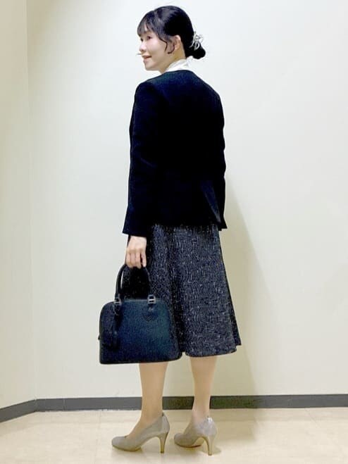 ブラック系のノーカラージャケット、ホワイト系のシャツ/ブラウス、ブラック系のスカートを着用したレディースの冬コーディネートの4枚目の写真