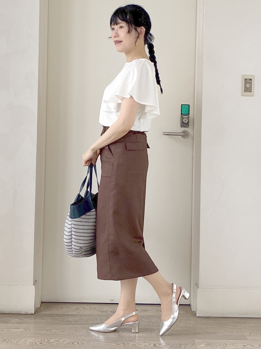 ホワイト系のTシャツ/カットソー、ブラック系のブルゾン、ブラウン系のスカートを着用したレディースの夏コーディネートの2枚目の写真