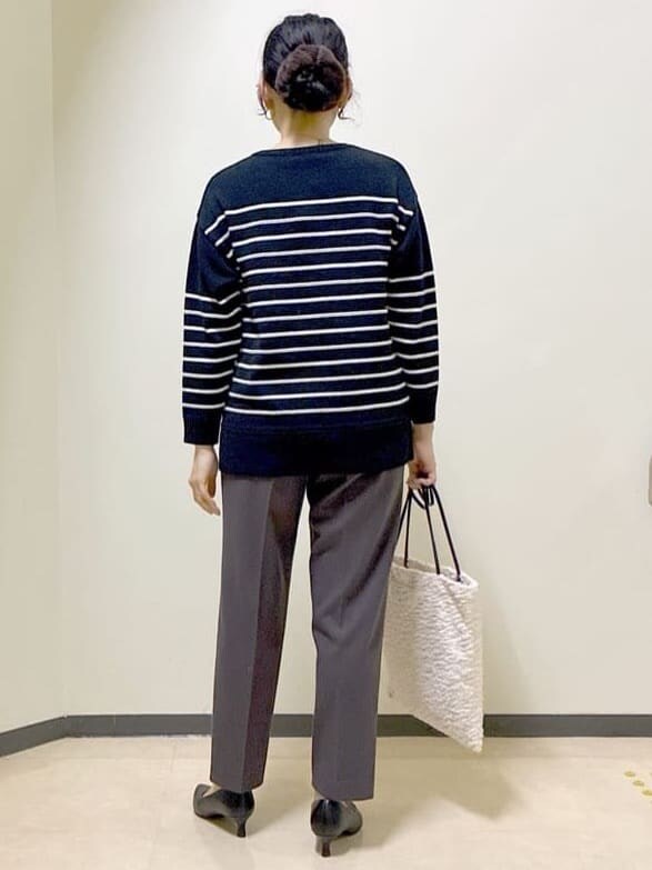 ブラック系のニット/セーター、ブラウン系のその他パンツ、ベージュ系のダウンジャケット/コートを着用したレディースの秋コーディネートの3枚目の写真