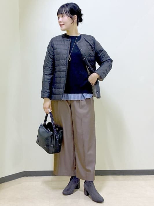 ブラック系のダウンジャケット/コート、ブラック系のニット/セーター、ブルー系のTシャツ/カットソーを着用したレディースの冬コーディネートの6枚目の写真