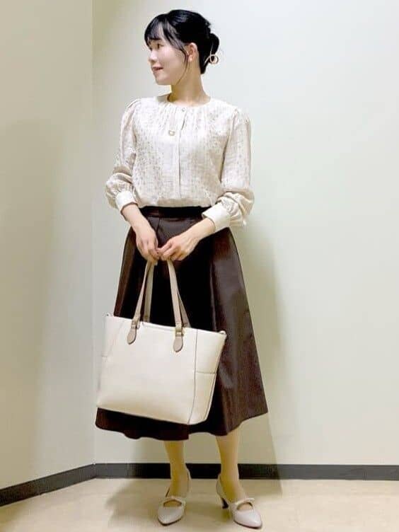 ベージュ系のシャツ/ブラウス、ブラウン系のスカート、ベージュ系のトートバッグを着用したレディースの春コーディネートの5枚目の写真