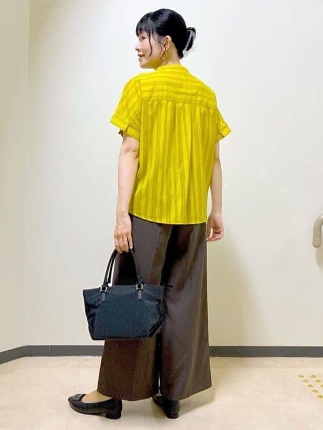 イエロー系のシャツ/ブラウス、ブラウン系のその他パンツ、ブラック系のトートバッグを着用したレディースの夏コーディネートの4枚目の写真
