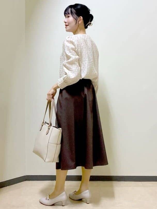 ベージュ系のシャツ/ブラウス、ブラウン系のスカート、ベージュ系のトートバッグを着用したレディースの春コーディネートの4枚目の写真