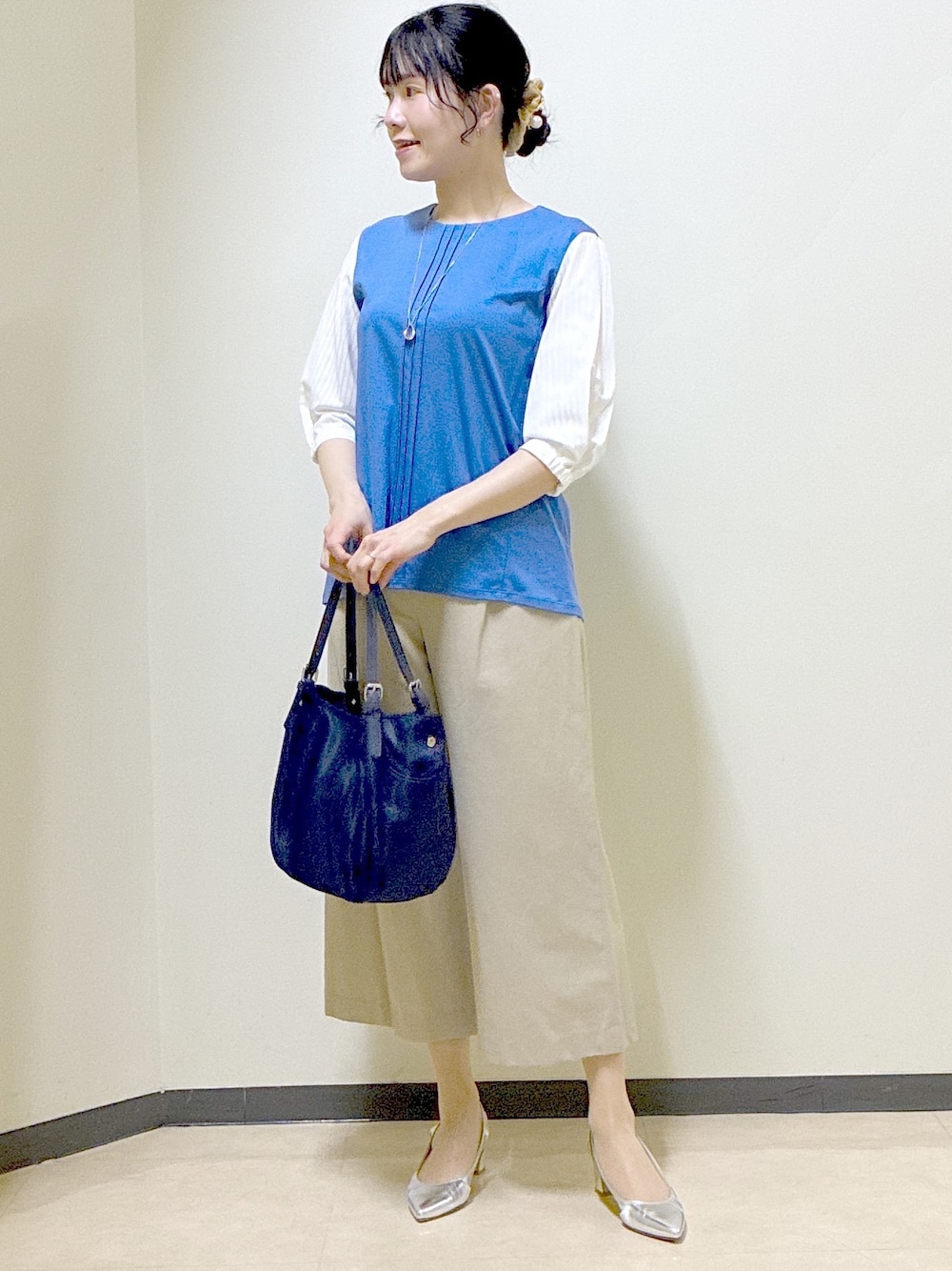 ブルー系のTシャツ/カットソー、ベージュ系のその他パンツ、ブルー系のショルダーバッグを着用したレディースの春コーディネートの6枚目の写真