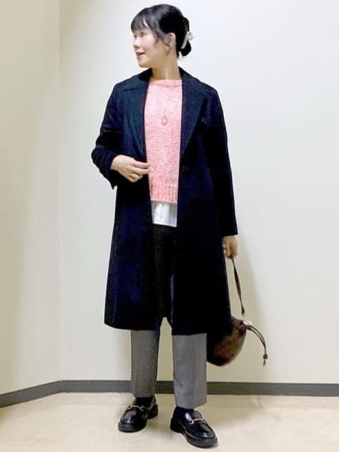 ブラック系のチェスターコート、レッド系のニット/セーター、ホワイト系のTシャツ/カットソーを着用したレディースの冬コーディネートの5枚目の写真