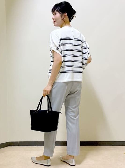 ホワイト系のニット/セーター、グレー系のその他パンツ、ブラウン系のスカートを着用したレディースの夏コーディネートの4枚目の写真