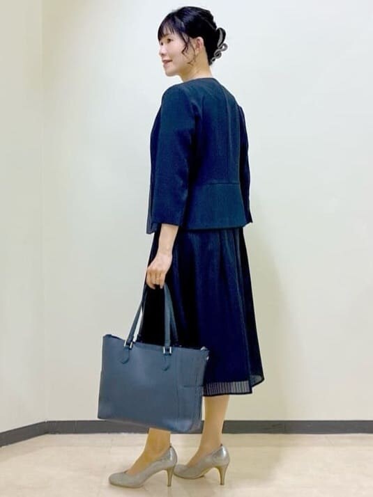 ブルー系のノーカラージャケット、グリーン系のシャツ/ブラウス、ブルー系のスカートを着用したレディースの夏コーディネートの4枚目の写真