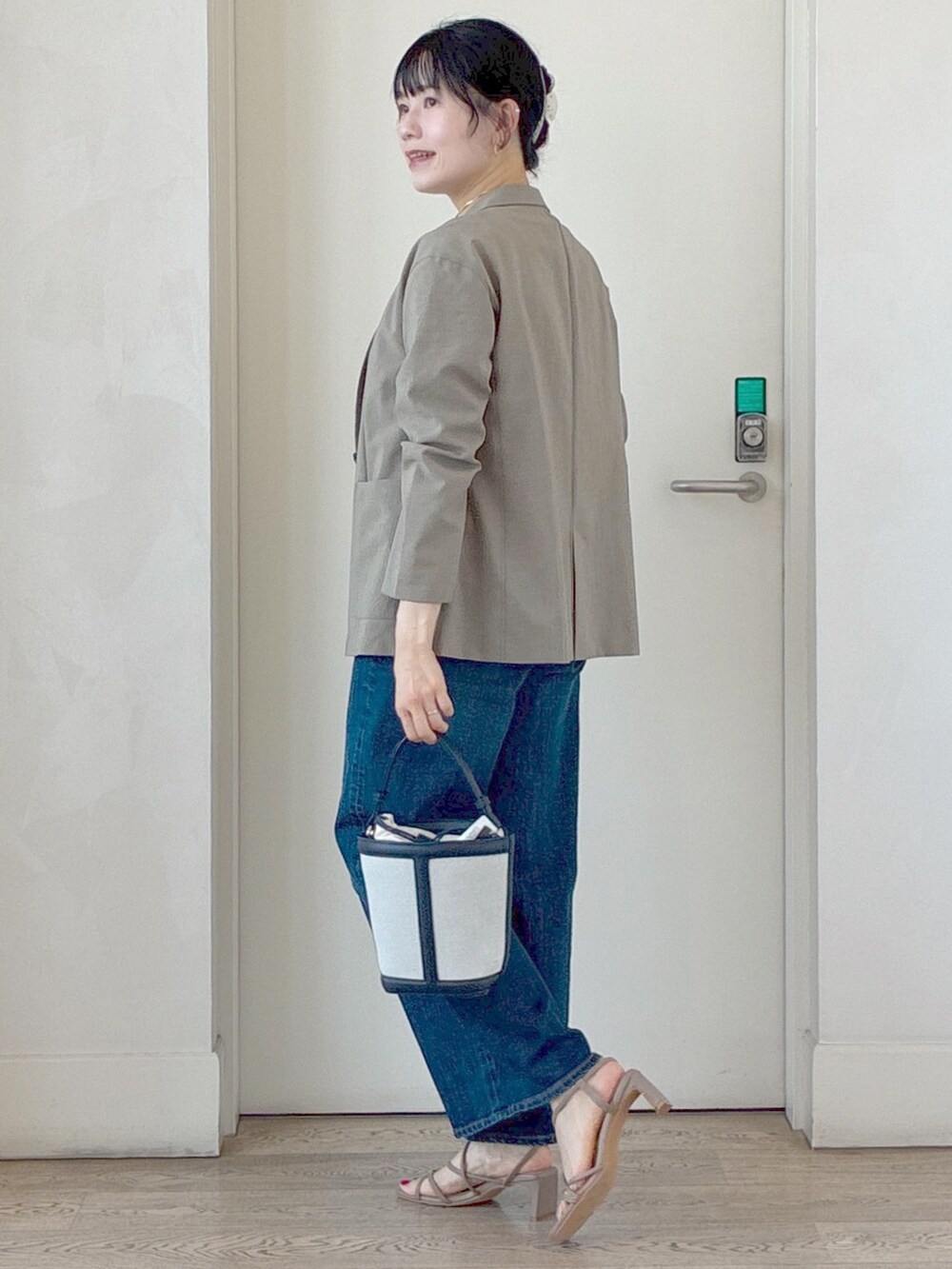 グリーン系のテーラードジャケット、ホワイト系のTシャツ/カットソー、ブルー系のデニムパンツを着用したレディースの夏コーディネートの4枚目の写真