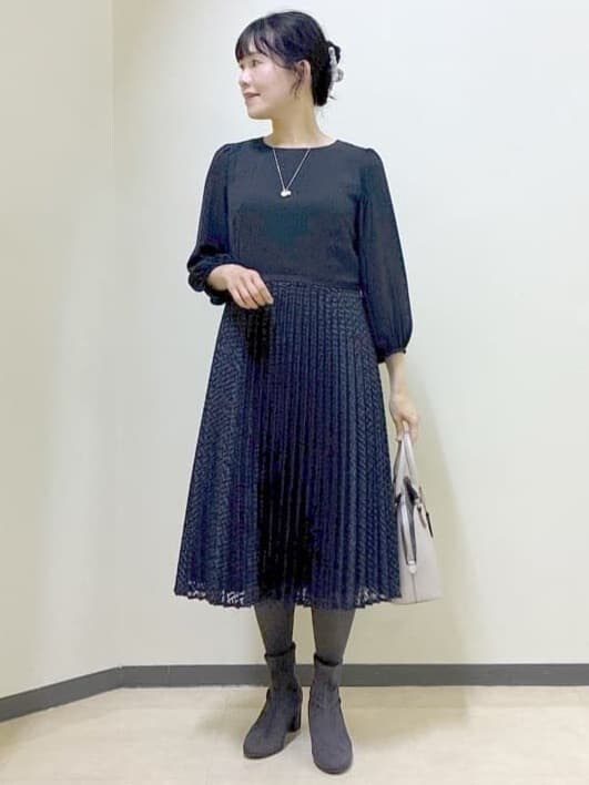 ブルー系のワンピース、グレー系のチェスターコート、ベージュ系のハンドバッグを着用したレディースの冬コーディネートの7枚目の写真