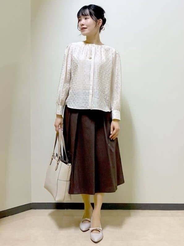ベージュ系のシャツ/ブラウス、ブラウン系のスカート、ベージュ系のトートバッグを着用したレディースの春コーディネートの9枚目の写真