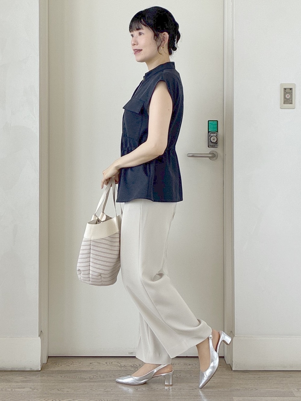 ブルー系のベスト、ベージュ系のその他パンツ、ベージュ系のトートバッグを着用したレディースの春コーディネートの2枚目の写真