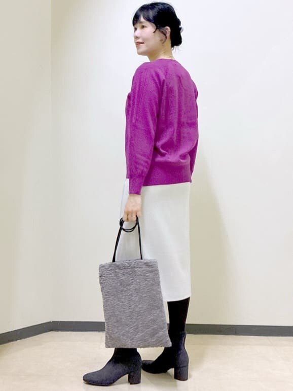 ピンク系のニット/セーター、ベージュ系のスカート、ブラック系のブルゾンを着用したレディースの冬コーディネートの4枚目の写真
