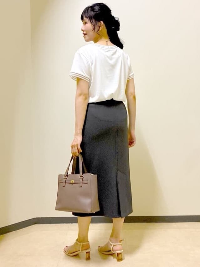 ホワイト系のTシャツ/カットソー、レッド系のカーディガン/ボレロ、グレー系のスカートを着用したレディースの秋コーディネートの4枚目の写真