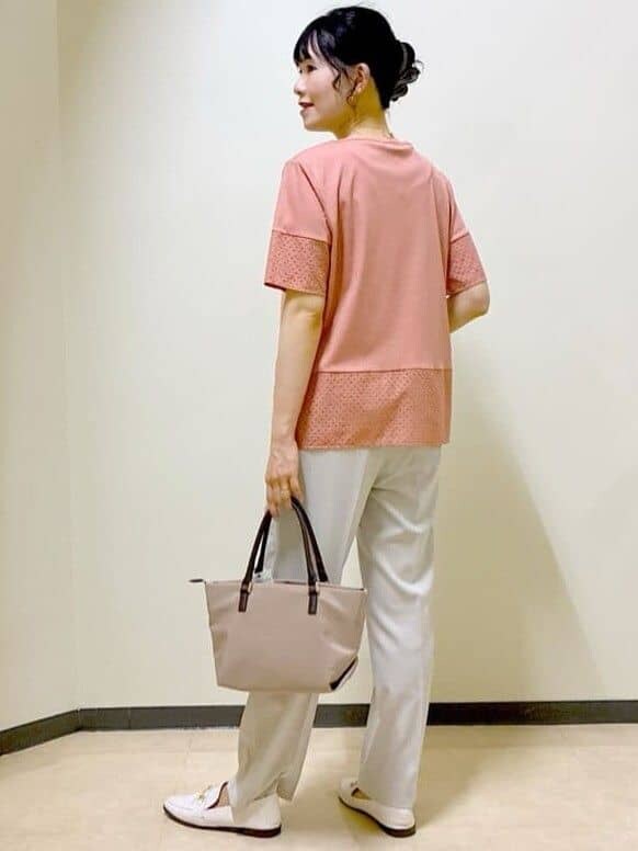 オレンジ系のTシャツ/カットソー、ベージュ系のその他パンツ、ベージュ系のトートバッグを着用したレディースの夏コーディネートの4枚目の写真