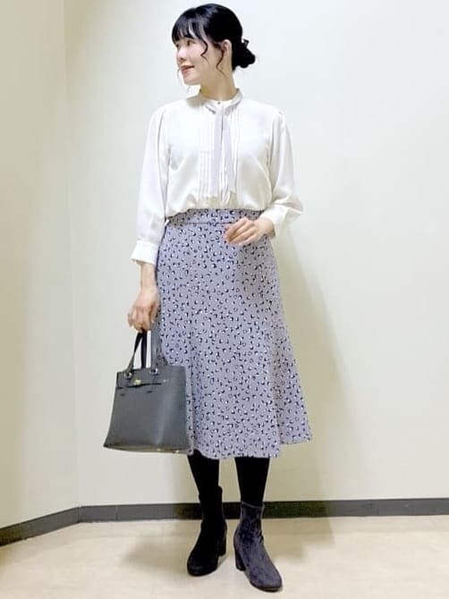ホワイト系のシャツ/ブラウス、グレー系のスカート、ブラック系のノーカラージャケットを着用したレディースの冬コーディネートの5枚目の写真