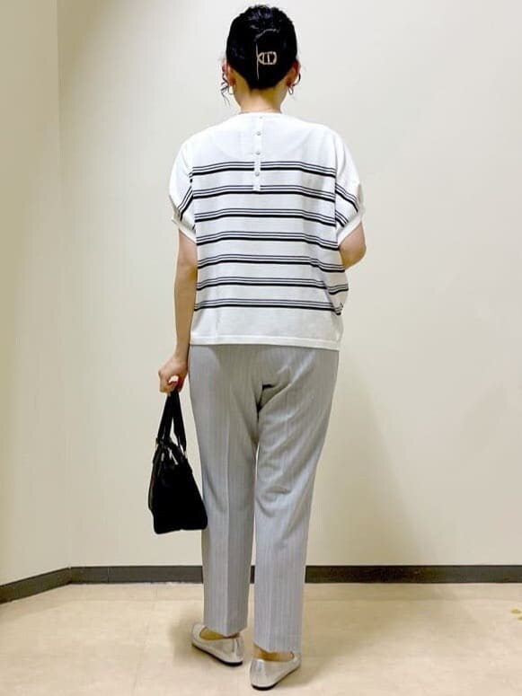 ホワイト系のニット/セーター、グレー系のその他パンツ、ブラウン系のスカートを着用したレディースの夏コーディネートの3枚目の写真