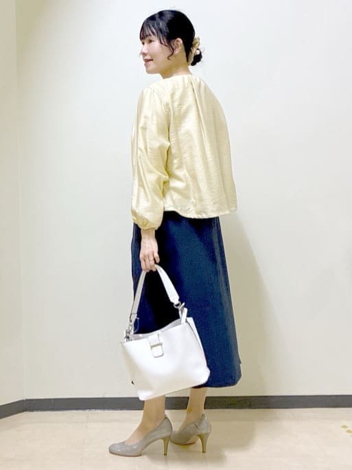 ベージュ系のブルゾン、ブルー系のスカート、ホワイト系のトートバッグを着用したレディースの春コーディネートの4枚目の写真