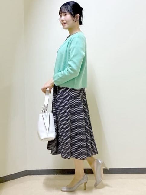 ベージュ系のワンピース、グリーン系のカーディガン/ボレロ、ホワイト系のトートバッグを着用したレディースの春コーディネートの2枚目の写真