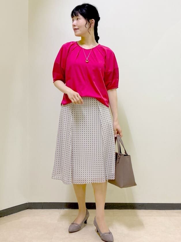 レッド系のTシャツ/カットソー、ベージュ系のスカート、ブラウン系のニット/セーターを着用したレディースの秋コーディネートの6枚目の写真