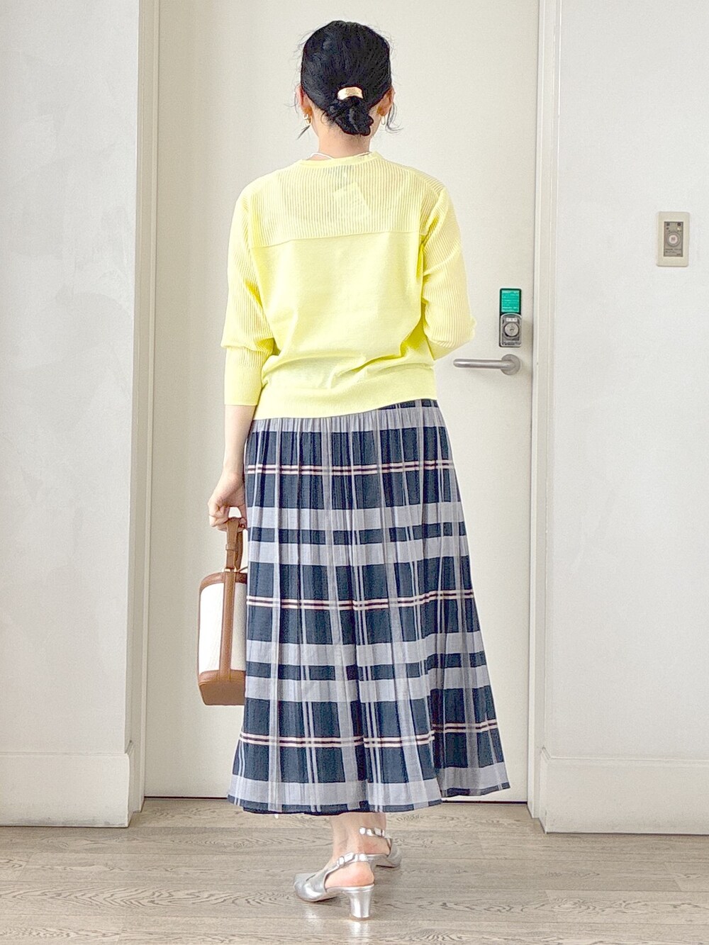 イエロー系のカーディガン/ボレロ、ベージュ系のタンクトップ、ブルー系のスカートを着用したレディースの夏コーディネートの3枚目の写真