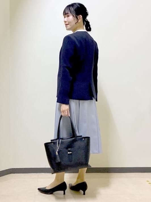 ブルー系のノーカラージャケット、ホワイト系のシャツ/ブラウス、ブラック系のトートバッグを着用したレディースの春コーディネートの4枚目の写真