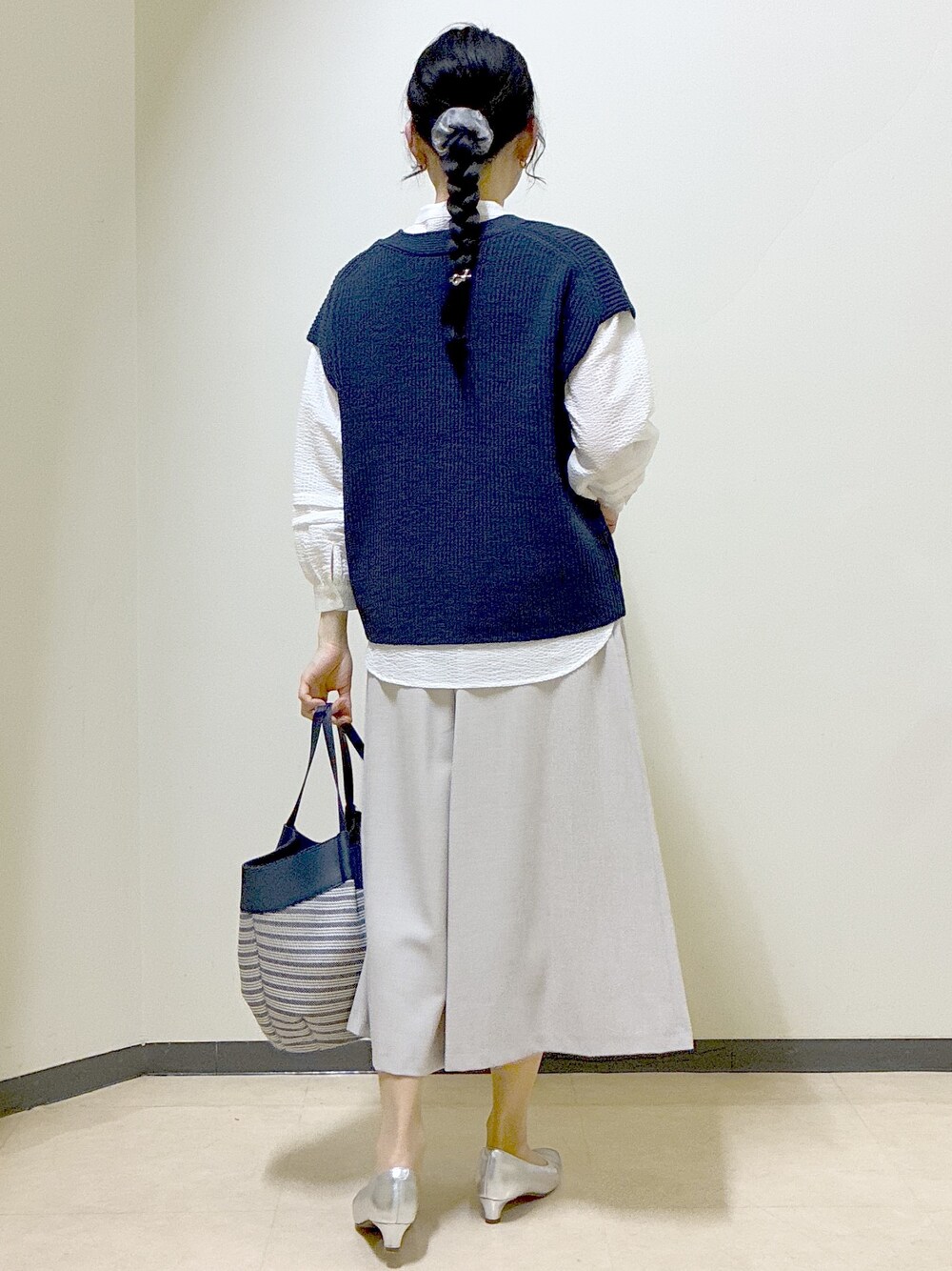 ブルー系のニット/セーター、ホワイト系のシャツ/ブラウス、ベージュ系のその他パンツを着用したレディースの春コーディネートの3枚目の写真