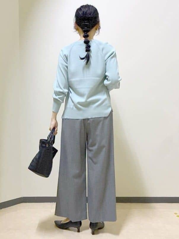 グリーン系のニット/セーター、グレー系のその他パンツ、ブラック系のトートバッグを着用したレディースの冬コーディネートの3枚目の写真