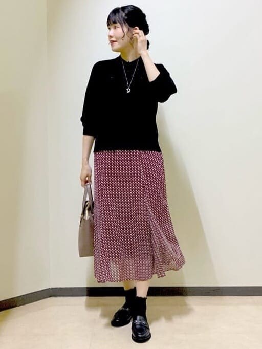 ブラック系のニット/セーター、グレー系のその他パンツ、レッド系のスカートを着用したレディースの秋コーディネートの10枚目の写真