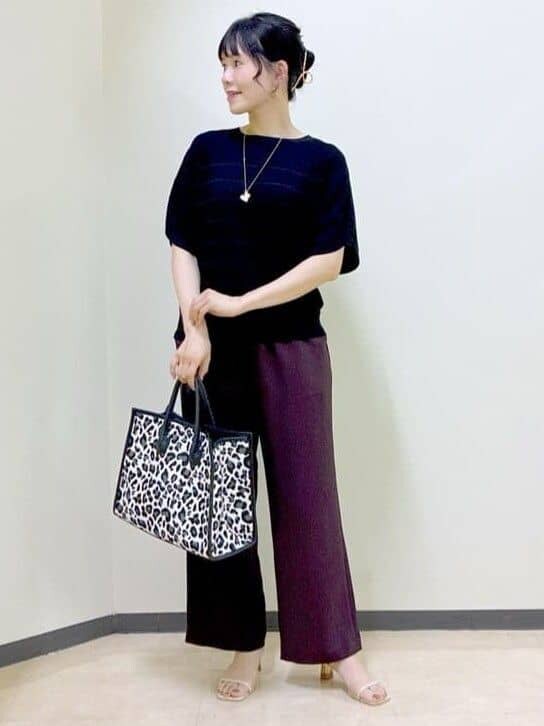 ブラック系のニット/セーター、ブラウン系のその他パンツ、ブラック系のトートバッグを着用したレディースの夏コーディネートの5枚目の写真