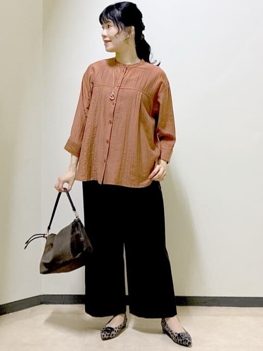 オレンジ系のシャツ/ブラウス、ブラック系のタンクトップ、ブラウン系のその他パンツを着用したレディースの秋コーディネートの6枚目の写真