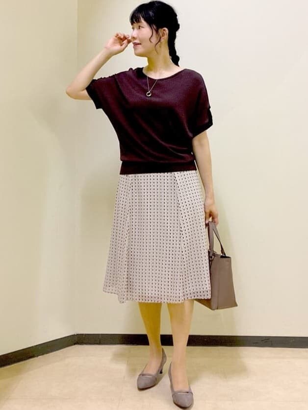 ブラウン系のニット/セーター、ベージュ系のスカート、レッド系のTシャツ/カットソーを着用したレディースの夏コーディネートの5枚目の写真