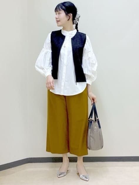ブラック系のベスト、ホワイト系のシャツ/ブラウス、イエロー系のその他パンツを着用したレディースの春コーディネートの5枚目の写真
