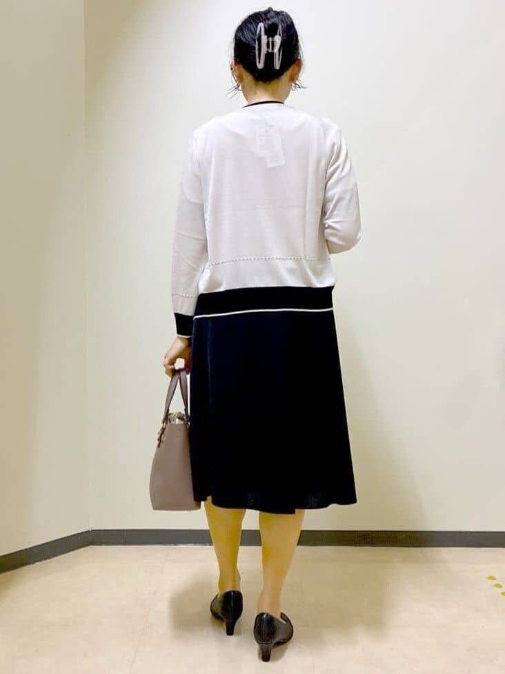 ベージュ系のカーディガン/ボレロ、ベージュ系のニット/セーター、ブラック系のスカートを着用したレディースの秋コーディネートの3枚目の写真