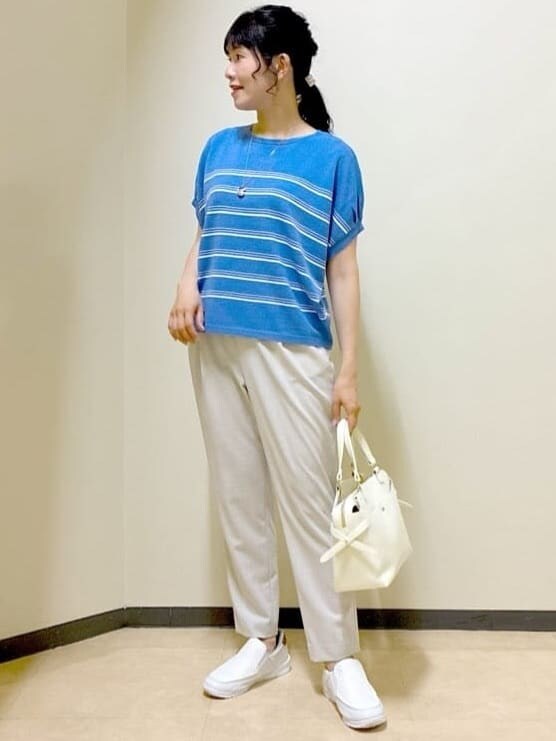 ブルー系のニット/セーター、ベージュ系のその他パンツ、ホワイト系のトートバッグを着用したレディースの夏コーディネートの5枚目の写真