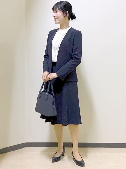 ブルー系のノーカラージャケット、ホワイト系のシャツ/ブラウス、ブルー系のスカートを着用したレディースの冬コーディネートの7枚目の写真