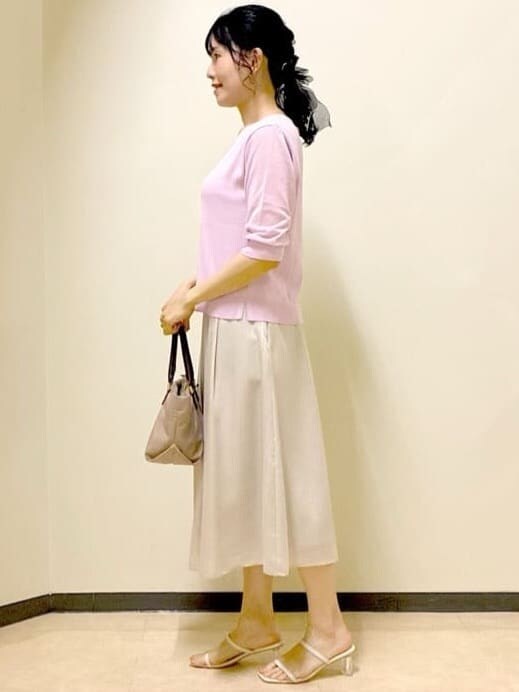 ピンク系のニット/セーター、ベージュ系のスカート、ベージュ系のトートバッグを着用したレディースの夏コーディネートの2枚目の写真