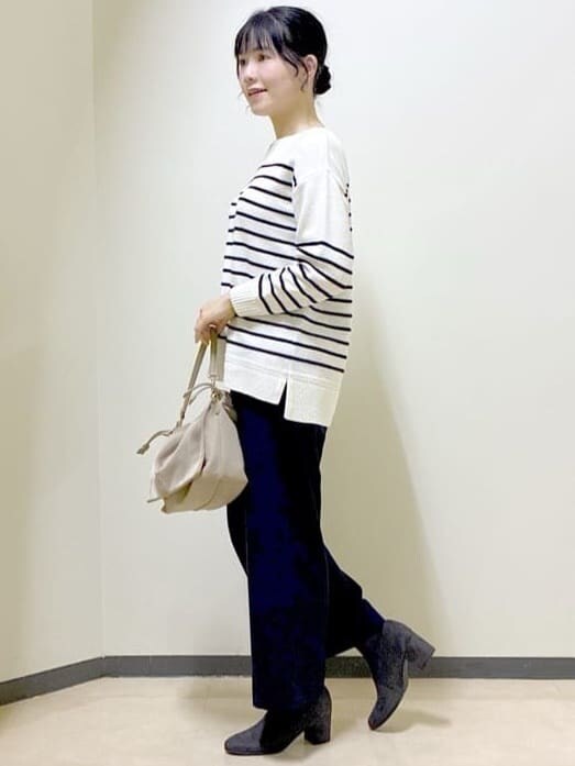 ホワイト系のニット/セーター、ブルー系のその他パンツ、ブラック系のダウンジャケット/コートを着用したレディースの冬コーディネートの2枚目の写真