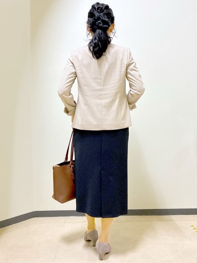 ベージュ系のノーカラージャケット、ブラック系のTシャツ/カットソー、ブラック系のスカートを着用したレディースの夏コーディネートの3枚目の写真